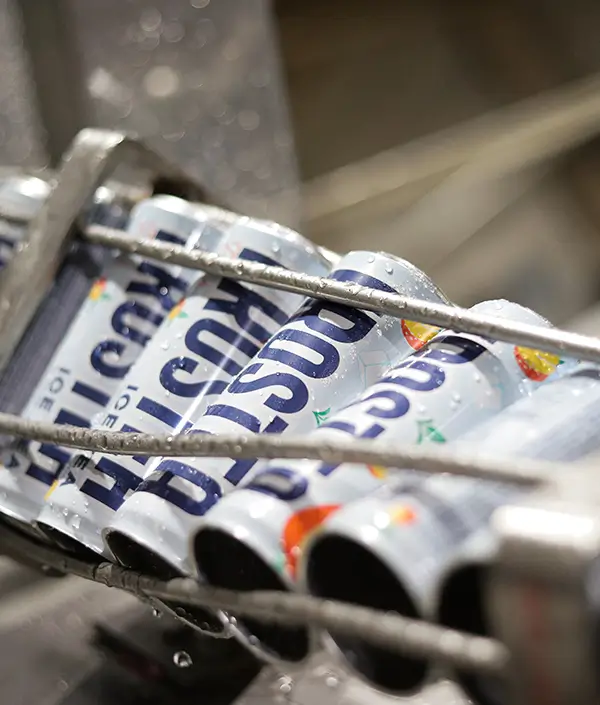Close-up view of Bisous energy drink cans moving on the conveyor