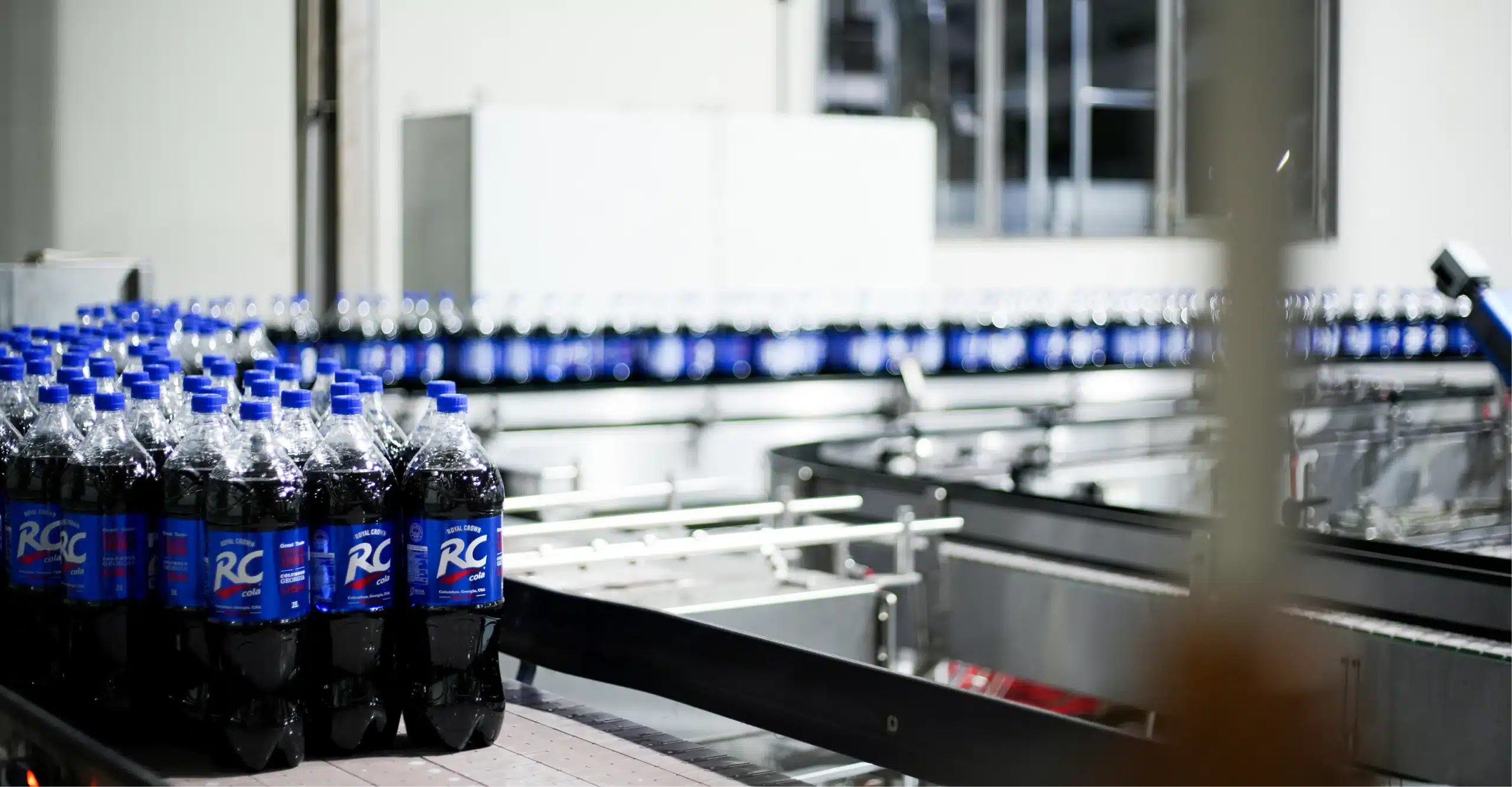 RC Cola bottles moving along an automated production line inside the factory